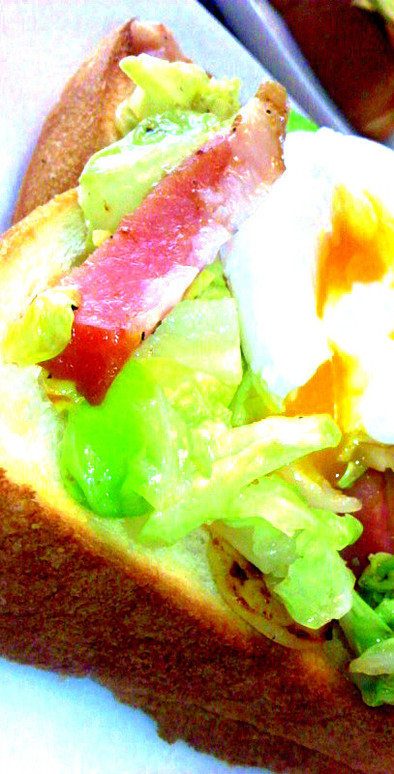 ベーコンキャベツ、卵をのせた朝のトーストの写真