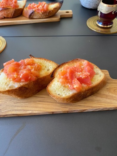 カリカリフランスパンに赤いトマトの写真