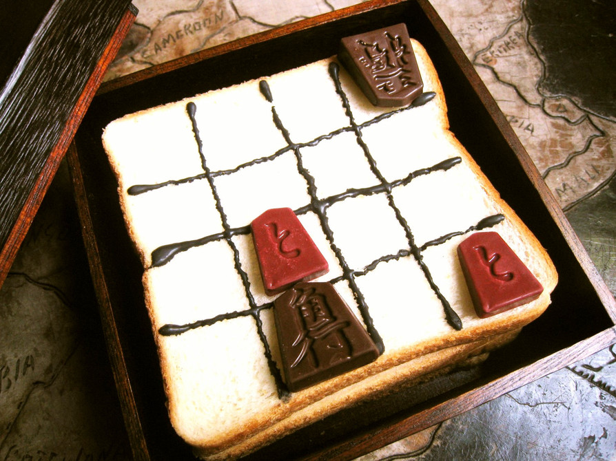 チョコレートで作った駒でパン上の詰将棋の画像